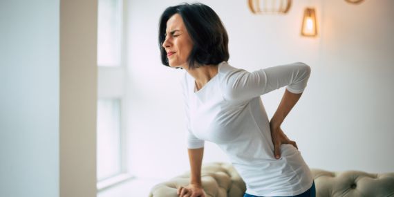 How To Prevent And Relieve Back Pain For Over 50s - woman holding here back