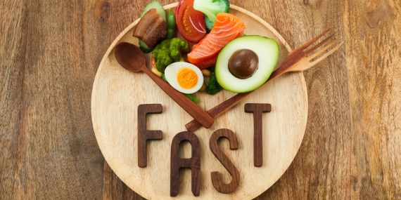 The Easy To Follow Intermittent Fasting Guide For Beginners - plate with food and fast sign