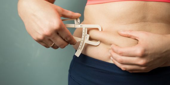 Measure Your Fitness Progress In 4 Easy Ways - woman using measuring tape