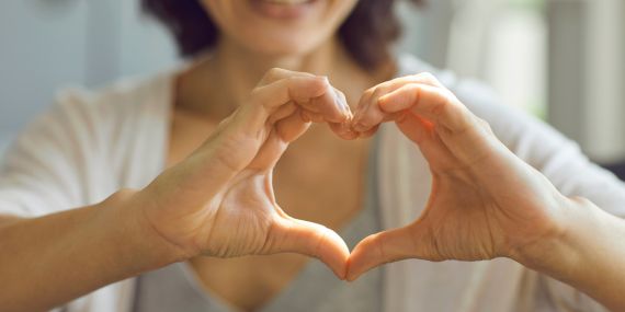 New Ways To Be Grateful During The Holidays - woman holding a heart sign