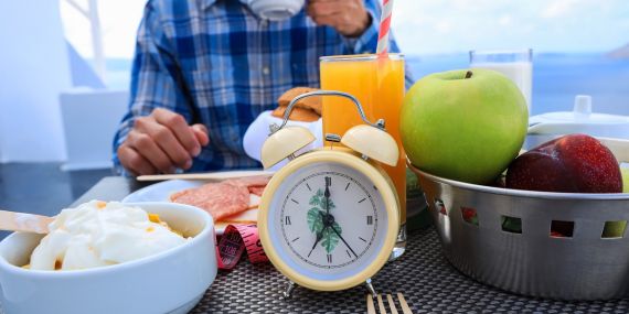 5 Strategies How Intermittent Fasting Helps You In Midlife - table with food and a clock