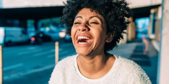 Moving Beyond the All-or-Nothing Wellness Mindset - woman laughing 