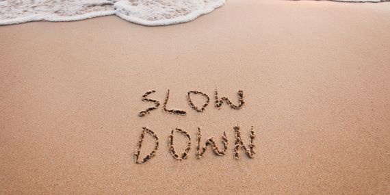 5 Habits To Transform Your Midlife - words in sand saying slow down