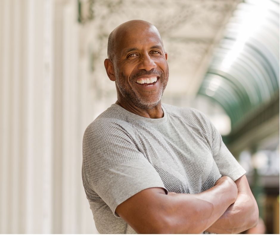 Man smiling in the camera, feeling strong and confident. virtual fitness coaching for midlife