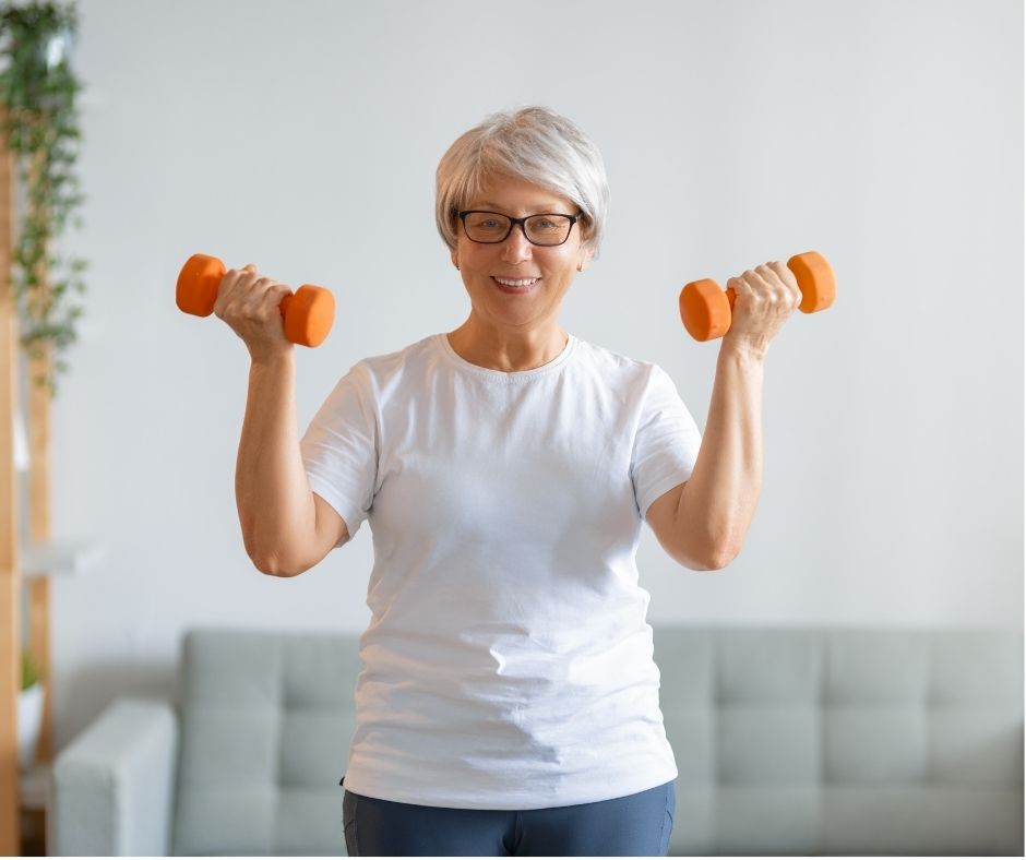 Midlife adults doing virtual fitness coaching session from home. woman lifting weights. online fitness and nutrition coaching with Heike Yates