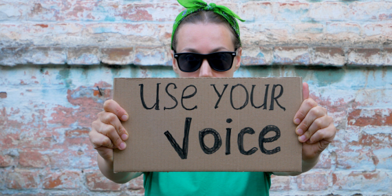 Reclaiming Your Voice in Midlife: How to Speak Up With Confidence (Without the Guilt) - women holding up sign saying use your voice