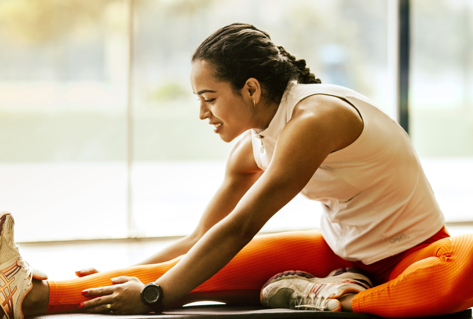 Midlife Fitness Mindset: The Real Reason Your Goals Don’t Stick. woman sitting on the floor stretching