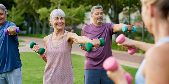 Midlife men and women working out with free weights. Midlife Fitness Mindset: The Real Reason Your Goals Don’t Stick