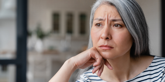 Fitness Over 50: Are Old Beliefs Holding You Back? Midlife woman frowning about her fitness progress.